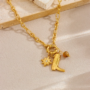 Gold plated vintage necklace with star, boot and tiger eye pendants on a chain
