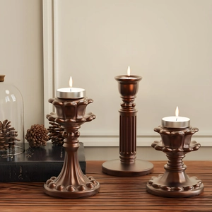 Drie vintage bronzen kandelaars in verschillende hoogtes met elegante Romeinse zuiltextuur
