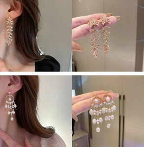 Detalle de pendientes de borla dorados con circón rosa y perlas de varias capas