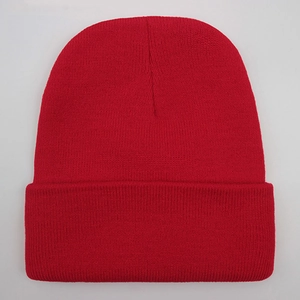 Detailed close-up of solid red knitted beanie showing premium textured wool yarn fabric