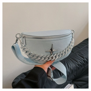Detailed view of light blue litchi grain faux leather crossbody bag with silver star logo
