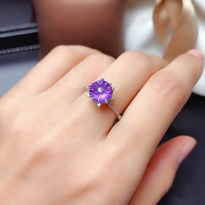 Sparkling amethyst ring with firework cut gemstone and silver band on a finger