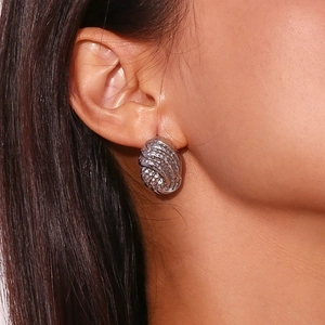 Silver twisted knot stud earrings in textured metal finish on female model ear