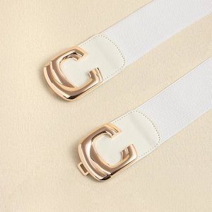 Detail of white elastic waist belts with golden C-shaped metal buckles and leather patches