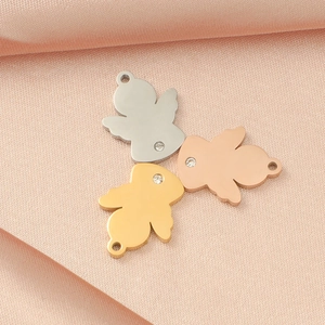 Detailed view of mirror-finish angel charms in silver, gold and rose gold with rhinestones
