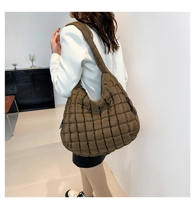 Quilted brown nylon cloud bag detail showing soft padded texture and wide shoulder strap