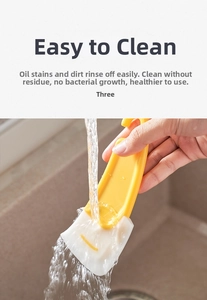 Vue macro d'un grattoir de cuisine jaune rincé sous l'eau pour enlever les taches d'huile