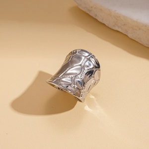 Detailed view of silver metal wide band ring with irregular geometric texture