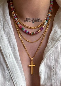 Detail of layered 18k gold plated necklaces with cross pendant and colorful beads
