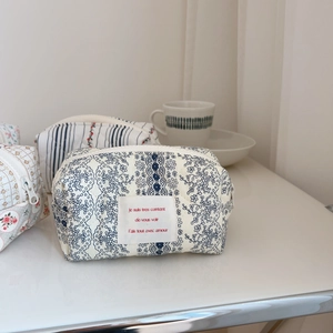 Detailed view of quilted cotton makeup bags with floral patterns and zipper closure