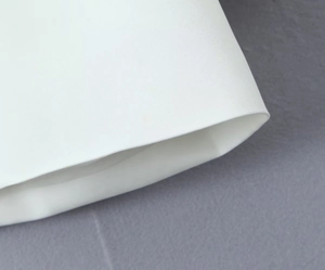 Close-up detail of white button-up blazer fabric texture and cuff stitching details