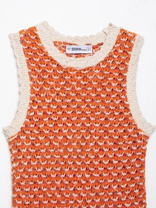 Close-up of orange and white wavy knit pattern and wave openwork texture detail