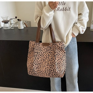 Détail du sac cabas léopard en toile avec lanières en cuir marron et grand intérieur