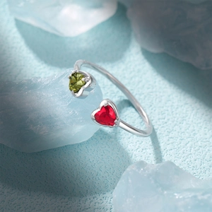 Macro detail of S925 silver ring featuring heart-cut red and green zircon gemstones