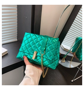 Close-up of metallic green quilted crossbody bag with gold chain and clasp detail