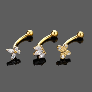 Detail of three golden G23 titanium eyebrow rings with butterfly and flower zircon stones