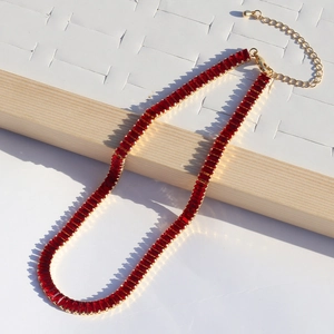 Golden necklace featuring a continuous row of rectangular red zircon stones with lobster clasp
