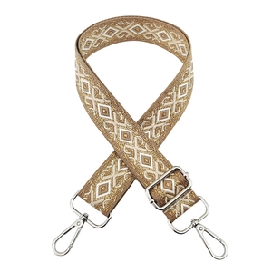 Close-up of beige and gold diamond patterned embroidery with silver metal hardware
