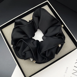 Elegant black satin scrunchie with sparkling white rhinestones in a minimalist gift box