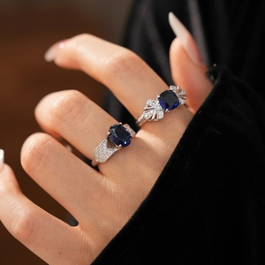 Gros plan de bagues élégantes en argent serties de saphirs bleus portées par un mannequin