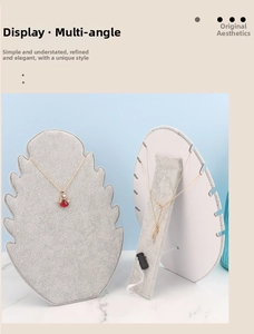 Detail view showing gray velvet necklace display stands with multiple slots and back support