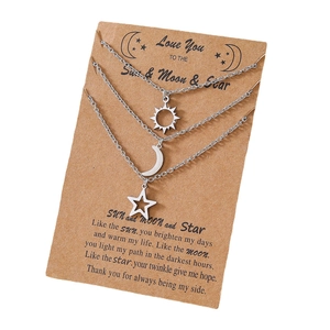 Vue détaillée des colliers soleil, lune et étoile sur des cartes cadeaux en kraft