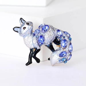 Sparkling silver fox brooch with blue crystals and black enamel on white background