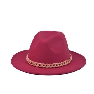 Detail of magenta felt fedora hat featuring a wide flat brim and pink chain link strap