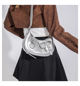 Détail du sac hobo argenté métallisé avec plusieurs poches et fermetures éclair à anneau