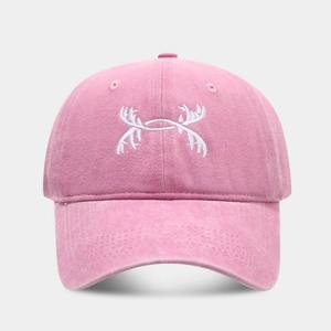 Detailed view of pink washed cotton baseball cap featuring white antler embroidery