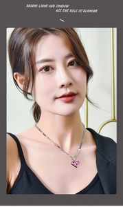 Detail of pink heart crystal pendant with silver mixed chain on a fashion model neck