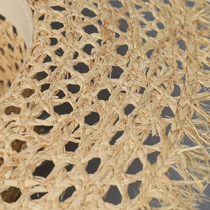 Macro shot of breathable hollow weave texture and natural frayed edge on raffia sun hat