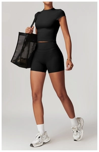 Dettaglio del set yoga nero con crop top aderente e pantaloncini sportivi a vita alta