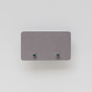 Close-up of emerald green cubic zirconia stud earrings with silver four-prong setting
