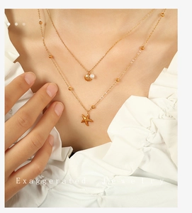 Detail of a double-layer starfish and shell necklace with gold plating on a model