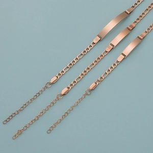 Three rose gold kid's ID bracelets with adjustable Figaro chains on blue background