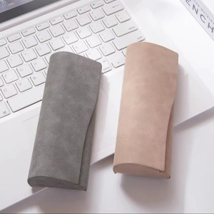 Minimalist matte nubuck sunglasses case in grey and beige on a laptop keyboard