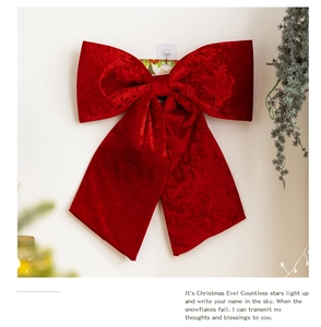 Detailed view of red velvet Christmas bow pendant with long streamers for festive hanging