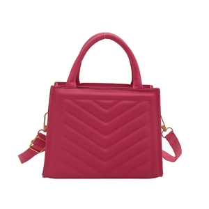 Magenta quilted crossbody bag with V-shaped stitching and gold-tone metal hardware