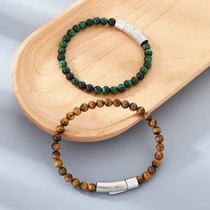Tiger eye and turquoise beaded bracelets with magnetic matte metal clasps on wood tray