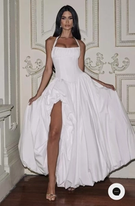 Détail d'une robe maxi corset blanche avec décolleté licou et jupe fendue élégante
