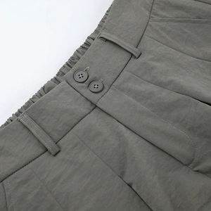 Detailansicht des Low-Waist Faltenrocks mit Doppelknopfverschluss und strukturiertem Stoff