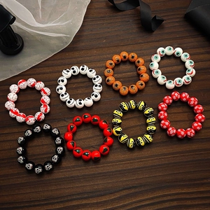 Détail de bracelets en perles d'Halloween avec motifs peints de crâne et citrouille