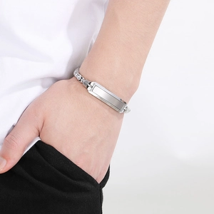 Nahaufnahme eines polierten Edelstahl-ID-Armbands mit Box-Kette am Herrenhandgelenk