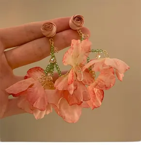 Detail of floral tassel earrings with pink silk petals and green beads for women