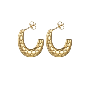 Détail de boucles d'oreilles dorées en C avec une texture métallique alvéolée unique