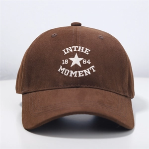 Brown baseball cap with white IN THE MOMENT embroidery and star pattern on soft crown
