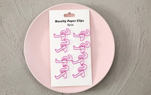 Detailed view of eight pink flamingo-shaped metal paper clips on a white display card