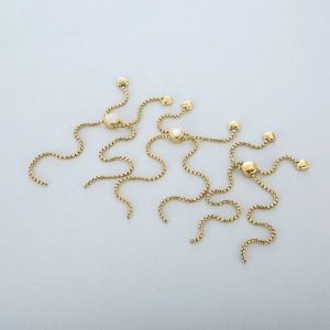 Three gold adjustable jewelry chain extenders with crystal sliders and heart pendants