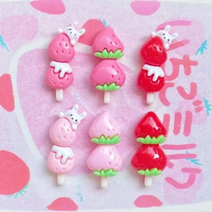 Detailed view of six resin strawberry bunny candy charms for DIY phone case crafts